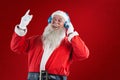 Composite image of santa claus listening to music on headphones Royalty Free Stock Photo