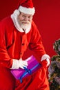 Composite image of santa claus putting christmas presents in christmas bag Royalty Free Stock Photo