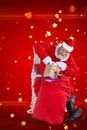 Composite image of santa claus putting presents in christmas bag Royalty Free Stock Photo