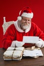 Composite image of santa claus reading wish lists Royalty Free Stock Photo