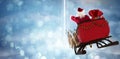 Composite image of santa claus riding on sled with gift box Royalty Free Stock Photo