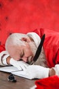 Composite image of santa claus sleeping at desk while writing letter Royalty Free Stock Photo