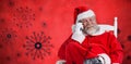 Composite image of santa claus using phone on chair Royalty Free Stock Photo