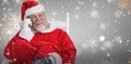Composite image of santa claus using phone on chair Royalty Free Stock Photo