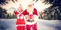 Composite image of santa and mrs claus smiling at camera offering gift