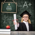 Composite image of schoolgirl with graduation robe and holding her diploma Royalty Free Stock Photo