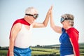 Composite image of senior couple wearing superman costume Royalty Free Stock Photo