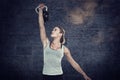 Composite image of serious muscular woman lifting kettlebell Royalty Free Stock Photo