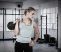 Composite image of serious muscular woman lifting kettlebell Royalty Free Stock Photo