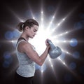 Composite image of serious muscular woman lifting kettlebell Royalty Free Stock Photo