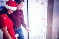 Composite image of side view of couple in christmas attire looking at wrist watch display Royalty Free Stock Photo