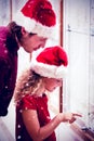 Composite image of side view of father and daughter in christmas attire looking at jewelry display