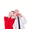 Composite image of silly couple holding hearts over their eyes Royalty Free Stock Photo
