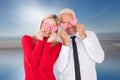 Composite image of silly couple holding hearts over their eyes Royalty Free Stock Photo