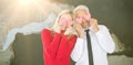 Composite image of silly couple holding hearts over their eyes Royalty Free Stock Photo