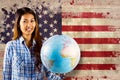 Composite image of smiling asian woman holding a globe Royalty Free Stock Photo