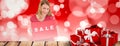 Composite image of smiling blonde showing a red sale poster Royalty Free Stock Photo