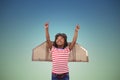 Composite image of smiling boy pretending to be pilot