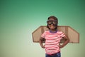 Composite image of smiling boy pretending to be pilot