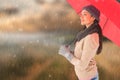 Composite image of smiling brunette holding red umbrella Royalty Free Stock Photo