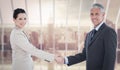 Composite image of smiling business people shaking hands while looking at the camera Royalty Free Stock Photo