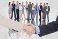 Composite image of smiling business people shaking hands while looking at the camera Royalty Free Stock Photo