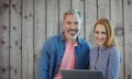 Composite image of smiling businessman and businesswoman are holding a laptop Royalty Free Stock Photo