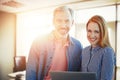 Composite image of smiling businessman and businesswoman are holding a laptop Royalty Free Stock Photo