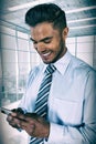 Composite image of smiling businessman using mobile phone Royalty Free Stock Photo