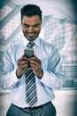 Composite image of smiling businessman using mobile phone Royalty Free Stock Photo