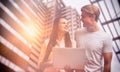 Composite image of smiling colleagues looking at each other while using laptop Royalty Free Stock Photo