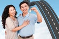 Composite image of smiling couple holding a set of keys Royalty Free Stock Photo