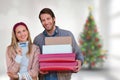 Composite image of smiling couple showing credit card and carrying boxes Royalty Free Stock Photo