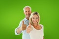 Composite image of smiling couple showing thumbs up together Royalty Free Stock Photo