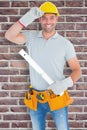 Composite image of smiling handyman holding spirit level Royalty Free Stock Photo