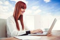 Composite image of smiling hipster businesswoman using her laptop Royalty Free Stock Photo