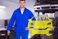 Composite image of smiling male mechanic holding tire Royalty Free Stock Photo