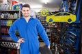 Composite image of smiling male mechanic holding tire Royalty Free Stock Photo