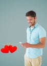 Composite image of smiling man texting and hanging red hearts Royalty Free Stock Photo