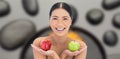 Composite image of smiling natural brunette holding apples in both hands Royalty Free Stock Photo