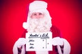 Composite image of smiling santa claus holding page Royalty Free Stock Photo