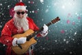 Composite image of smiling santa claus playing guitar while standing Royalty Free Stock Photo