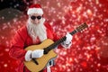 Composite image of smiling santa claus playing guitar while standing Royalty Free Stock Photo