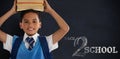 Composite image of smiling schoolboy carrying books on head over white background Royalty Free Stock Photo