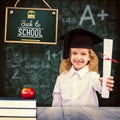 Composite image of smiling schoolgirl with graduation cap and holding her diploma Royalty Free Stock Photo