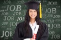 Composite image of a smiling woman looking at the camera while dressed in her graduation gown Royalty Free Stock Photo