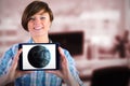 Composite image of smiling woman showing digital tablet with blank screen Royalty Free Stock Photo