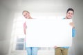 Composite image of smiling young couple holding a blank sign Royalty Free Stock Photo