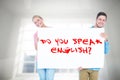 Composite image of smiling young couple holding a blank sign Royalty Free Stock Photo