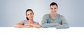 Composite image of smiling young couple looking over a wall Royalty Free Stock Photo